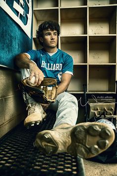 a baseball player sitting in the dugout with his mitt and ball glove on