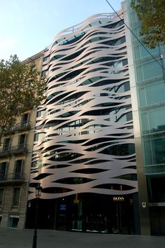 a tall building with lots of windows on it's side in front of a tree