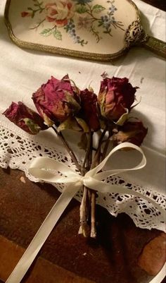 some flowers are sitting on top of a piece of paper with a ribbon around it