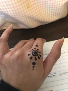 a person's hand with a tattoo on it and writing in a note pad