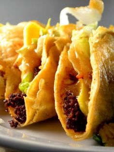 some tacos are on a plate and ready to be eaten