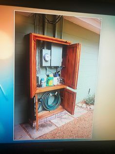 an open cabinet with water hoses in it