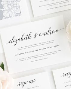 the wedding stationery is laid out on top of each other, with white flowers