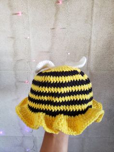 a crocheted yellow and black hat with horns on it's brim