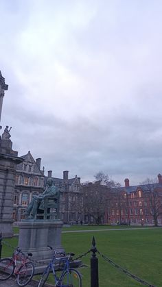 two bikes parked next to each other in front of a building with a clock tower