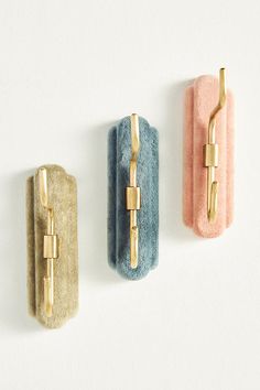 three gold, blue and pink wall hooks