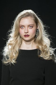 a woman with long blonde hair and blue eyes on the catwalk at a fashion show