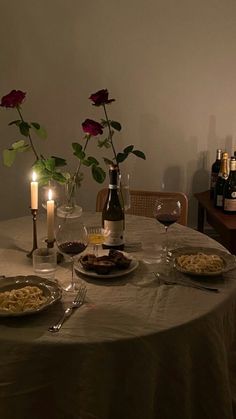 the table is set for two with wine and food