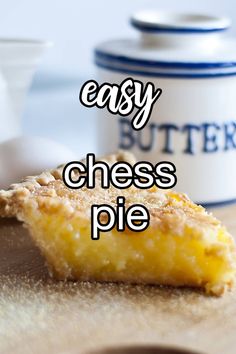 a piece of cheese pie sitting on top of a cutting board next to a butter container