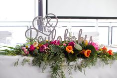 a table with flowers and a cake topper on it