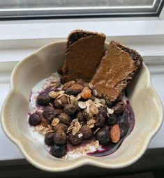 a bowl filled with chocolate and nuts on top of a window sill