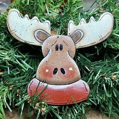 a wooden moose ornament hanging from a christmas tree