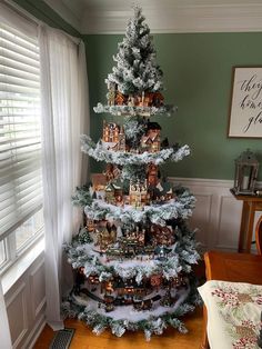 a christmas tree is decorated with miniature houses