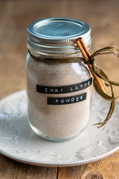 a glass jar filled with sand on top of a white plate