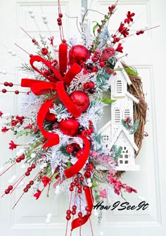 a wreath with red and white decorations hanging on a door