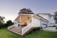 a white house sitting on top of a lush green field