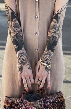 a woman with tattoos on her arms holding a purse