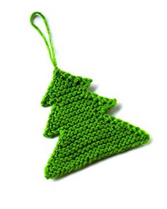 a green crocheted christmas tree ornament hanging from a string on a white background