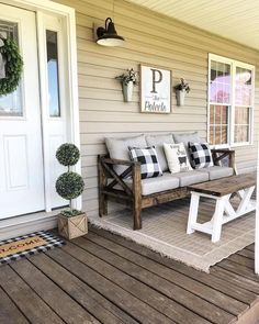 a wooden bench sitting on top of a porch next to a white door and window