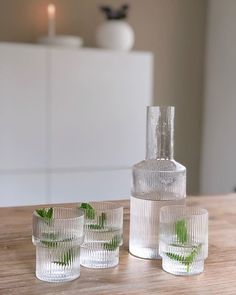 four glasses and a bottle on a table