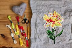 an image of a flower on a t - shirt next to crochet hooks and scissors