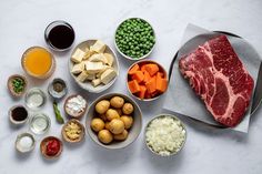 meat, potatoes, peas, carrots and other ingredients are arranged on a table