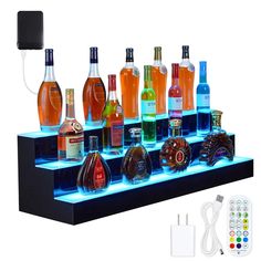 there are many different types of liquor on the shelf with remotes next to it