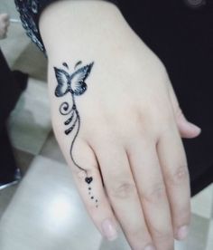 a woman's hand with a butterfly tattoo on it