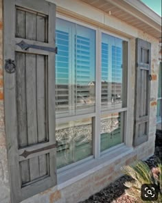 an old window with shutters reflecting the water