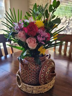 a vase filled with flowers sitting on top of a wooden table