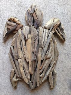 an animal made out of drift wood sitting on the ground