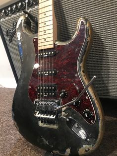 an electric guitar sitting on top of a carpeted floor