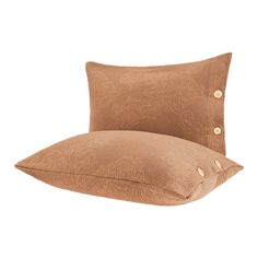 two pillows sitting next to each other on top of a white surface with gold buttons