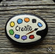 a painted rock with the word create on it