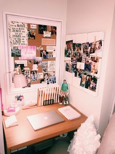 a desk with a laptop and pictures on the wall