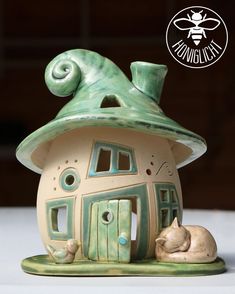 a ceramic house with a cat sleeping on the floor