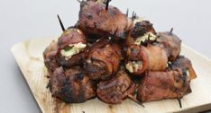 there are skewered meats with toothpicks on the cutting board, ready to be eaten