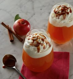 two glasses of apple cider with whipped cream on top