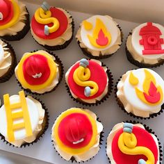 twelve cupcakes decorated in the shape of fire engines