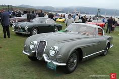 some very nice looking cars parked in the grass