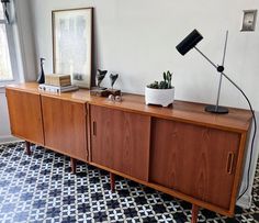 a room with a large wooden cabinet and black and white checkered tile flooring