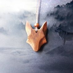 a wooden dog ornament hanging from a string on a black background with fog