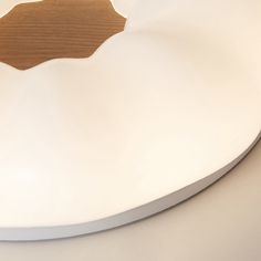 a white plate with a wooden edge on a counter top, in the shape of a heart