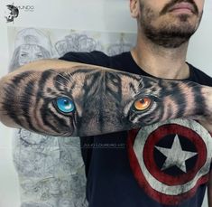 a man with a tattoo on his arm that has an image of a tiger's face and blue eyes