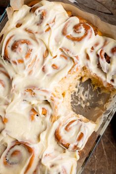 a pan filled with cinnamon rolls covered in icing