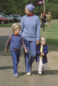 a woman and two children walking down the street