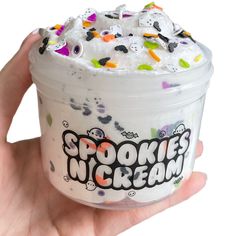 a hand holding up a cup with spookies in cream on the top and bottom