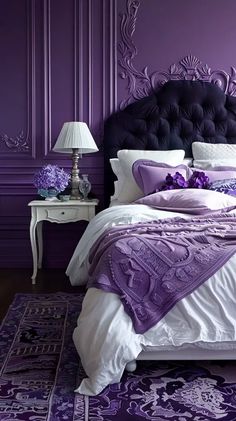 a bedroom with purple walls and white bedding, an ornate headboard and foot board