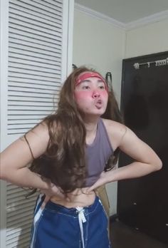 a girl with long hair standing in front of a refrigerator