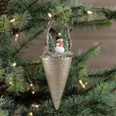 a snowman ornament hanging from a christmas tree